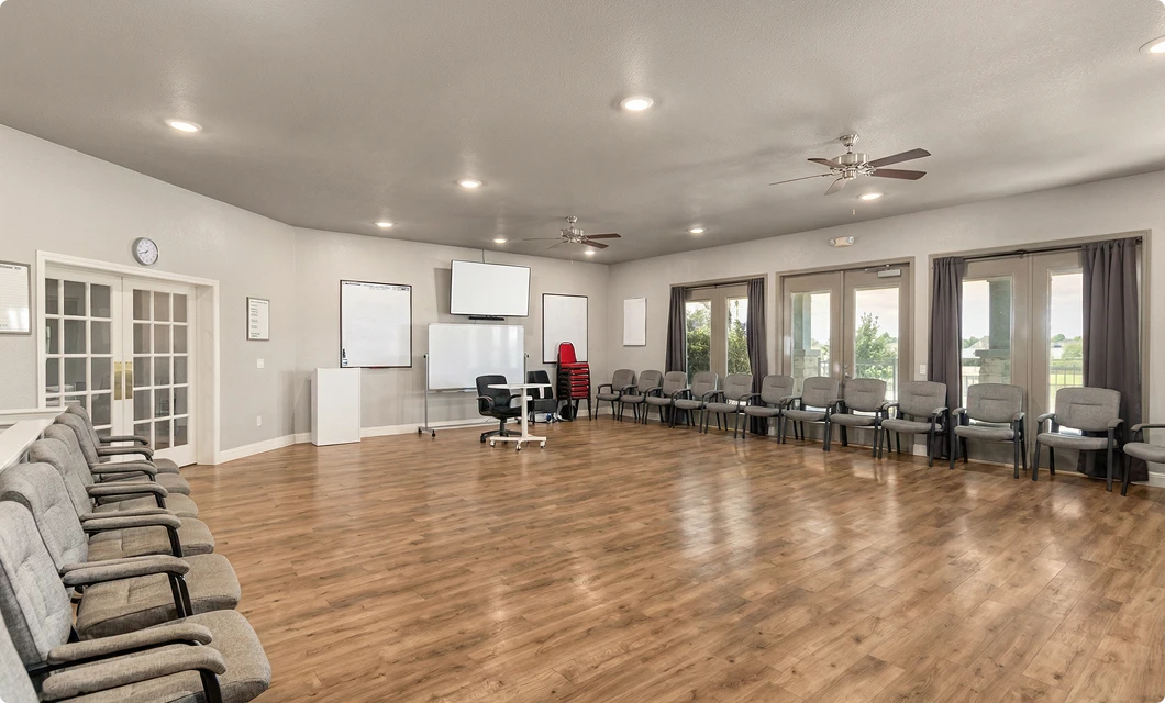 Large activity room with hardwood floors and natural light